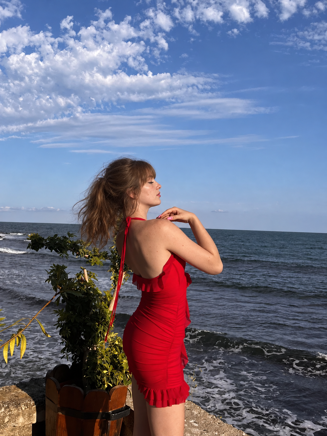 Hannah in a red dress beside the sea